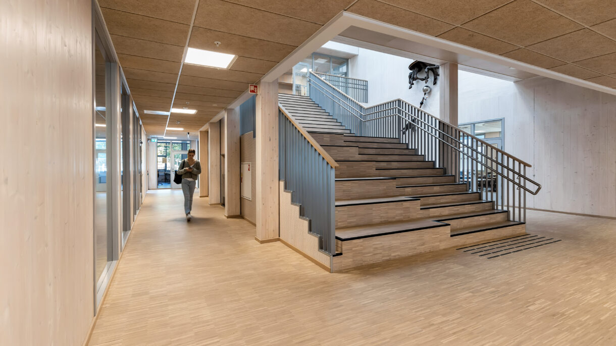 Interiør skolebygg. Hovedtrapp med naturlig overlys. Foto