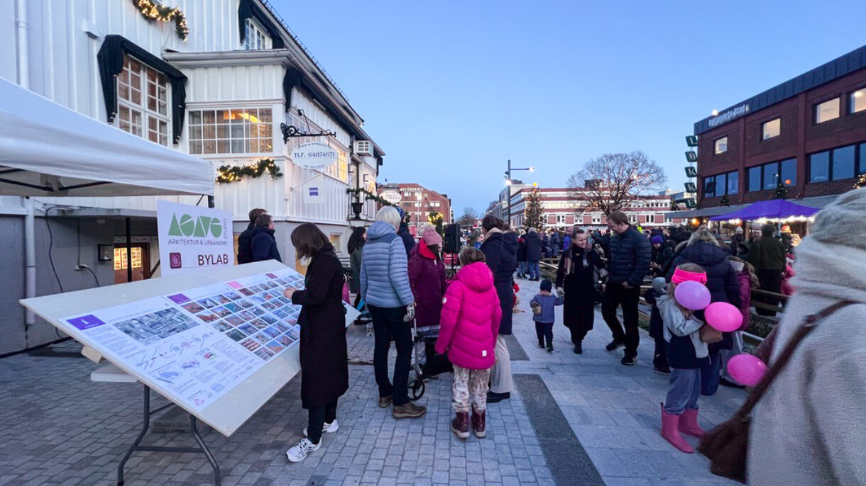 Plakatutstilling i gate med masse mennesker og ballonger. Foto.