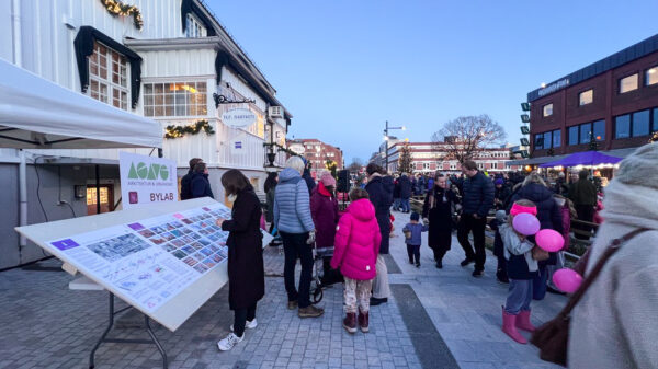 Plakatutstilling i gate med masse mennesker og ballonger. Foto.