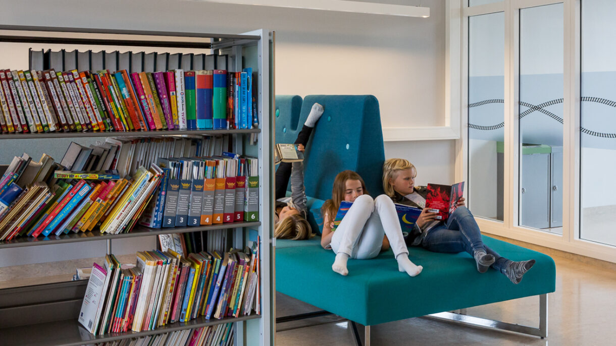 Barn som leser i biblioteket. Foto