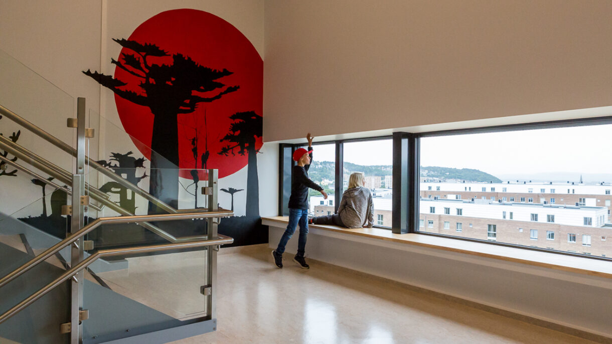 Barn og kunstnerisk utsmykning i trapperom. Foto