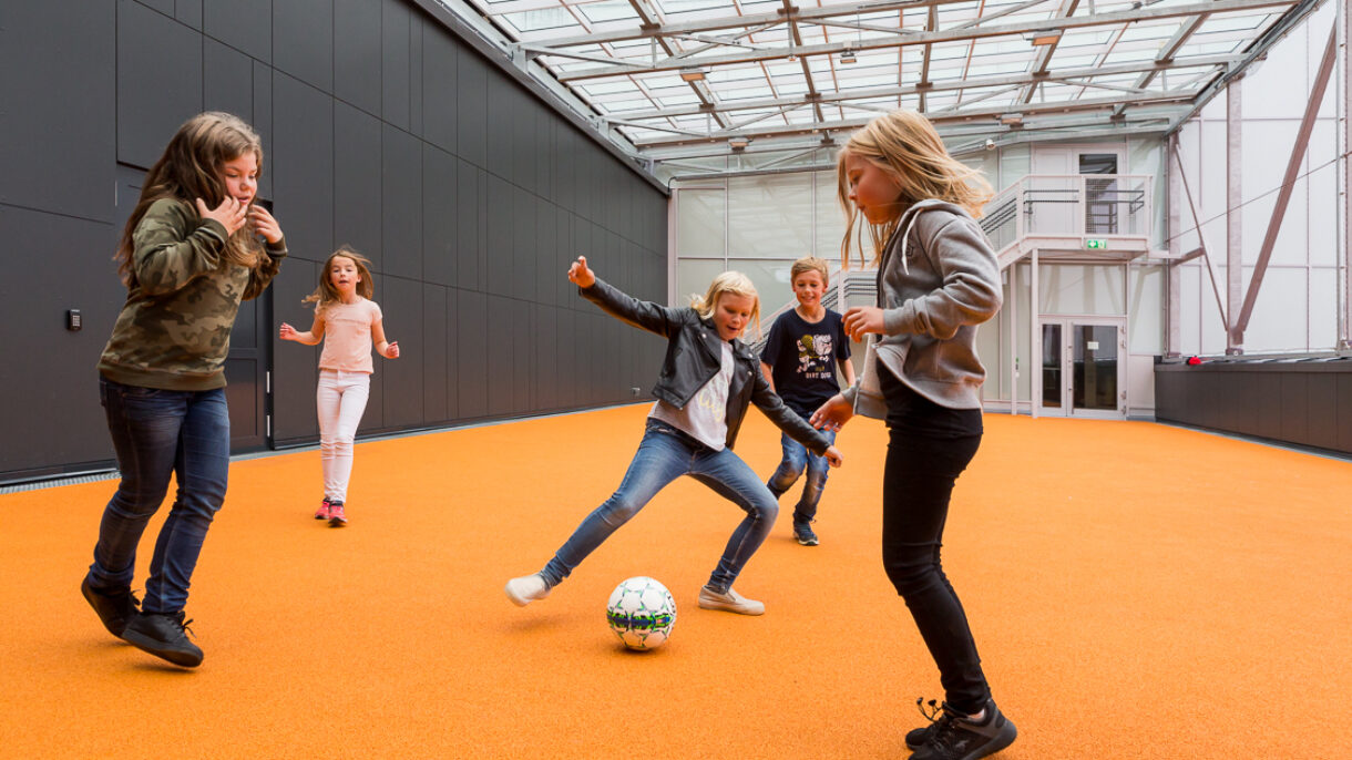 Barn som spiller ball. Foto
