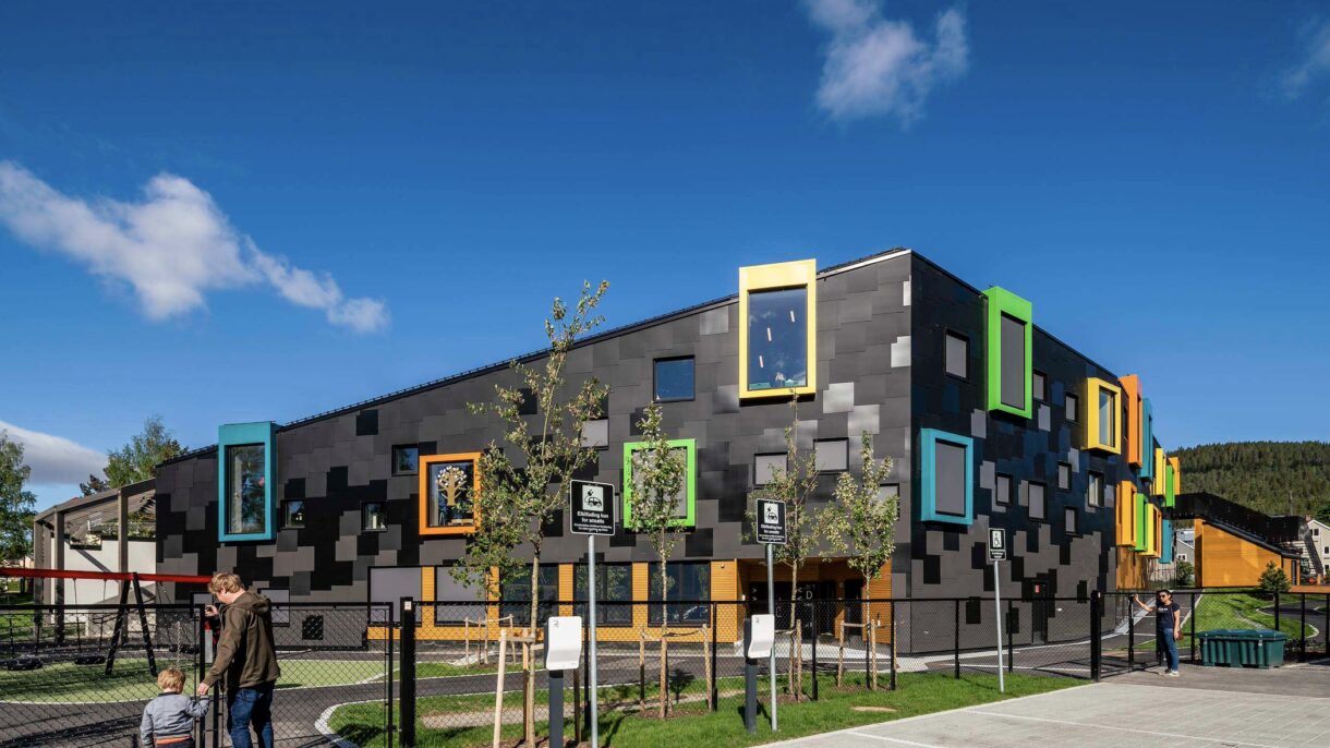 Barn og voksen på vei inn i barnehagen. Foto