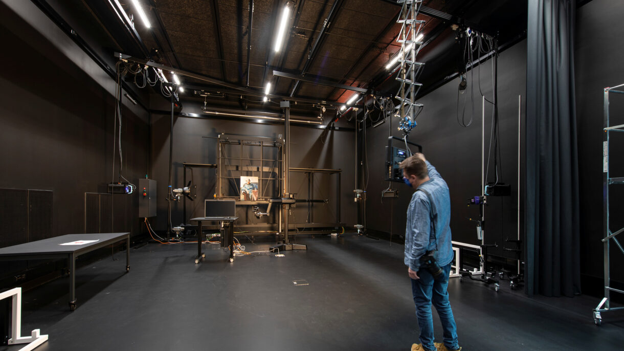 Fotograf i aksjon i fotostudioet. Sort interiør. Foto.