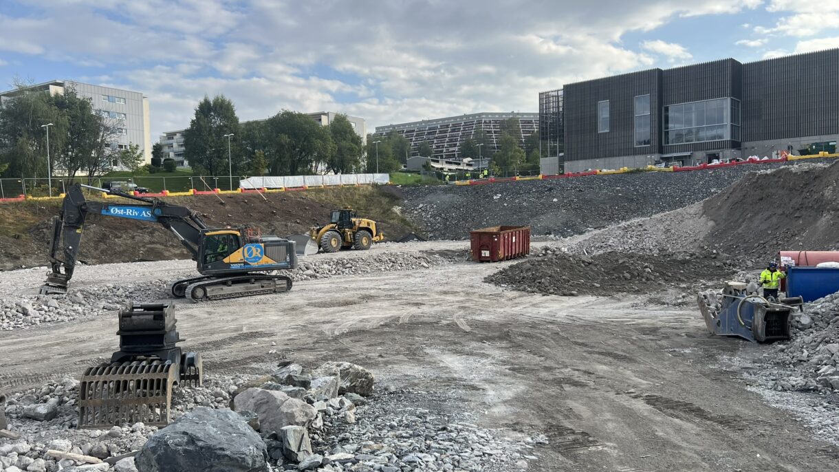 Byggegrop med gravemaskin. Foto.