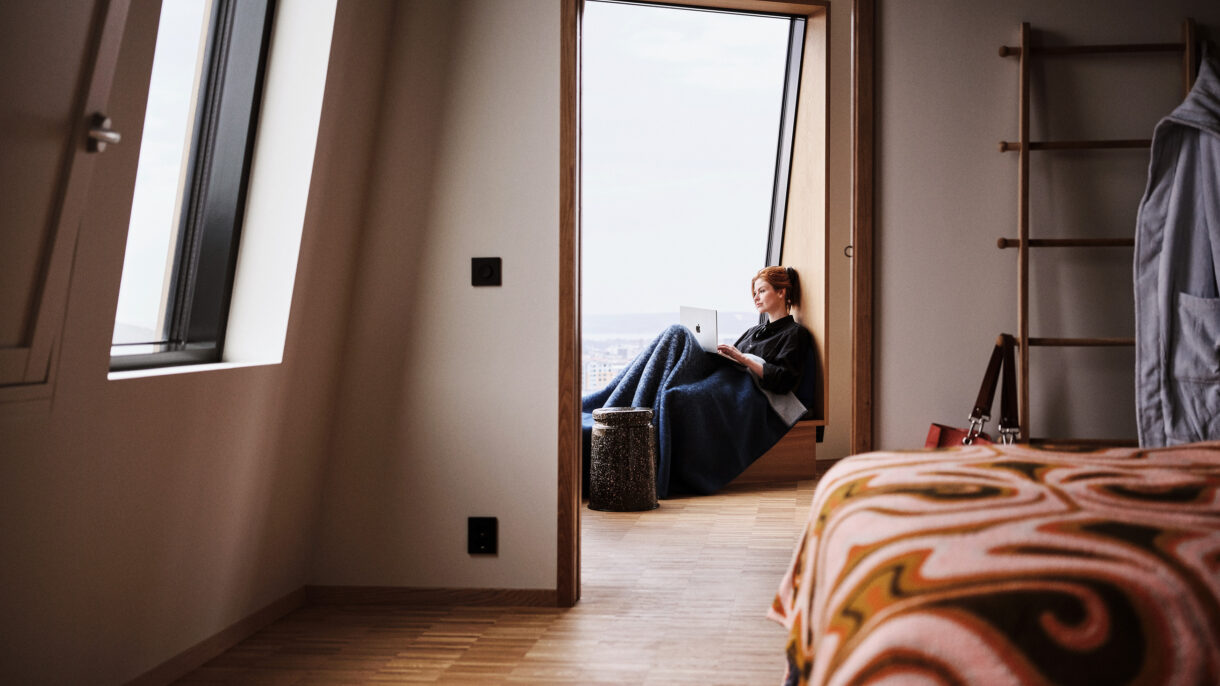 Interiør leilighet. Beboer sitter i vinduskarmen.