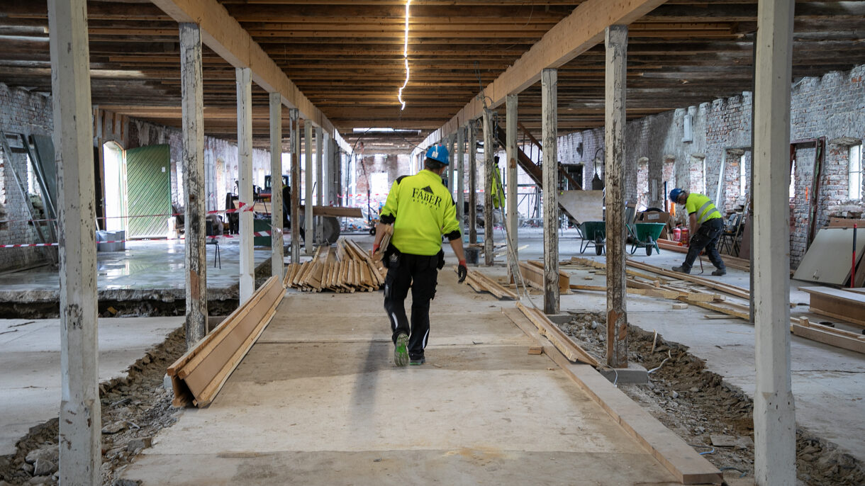 Person i verneutstyr innendørs på byggeplass. Foto.