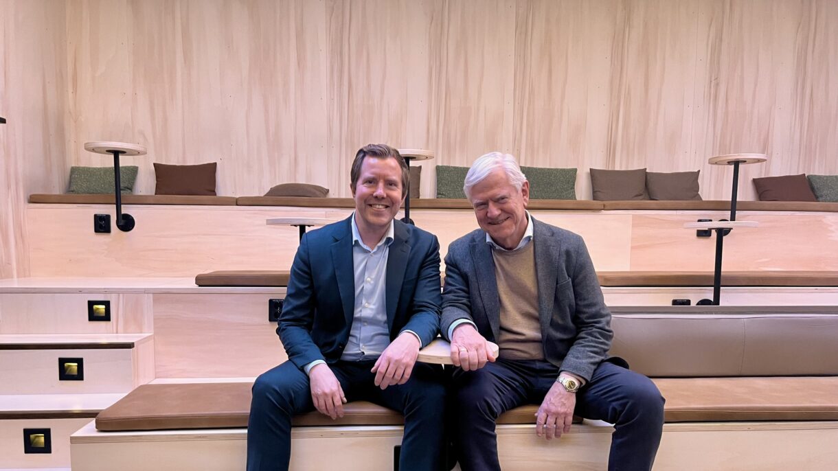 To menn sitter på en benk. Foto.