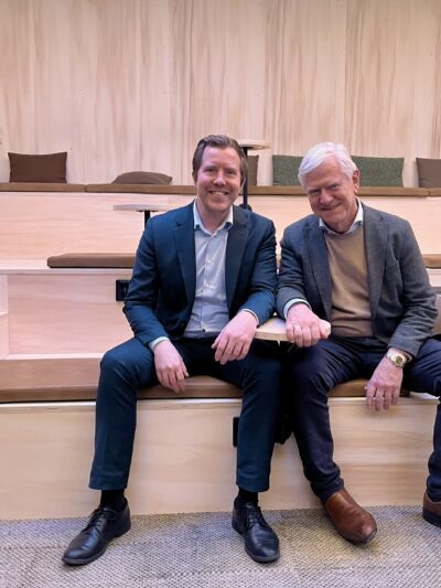 To menn sitter på en benk. Foto.