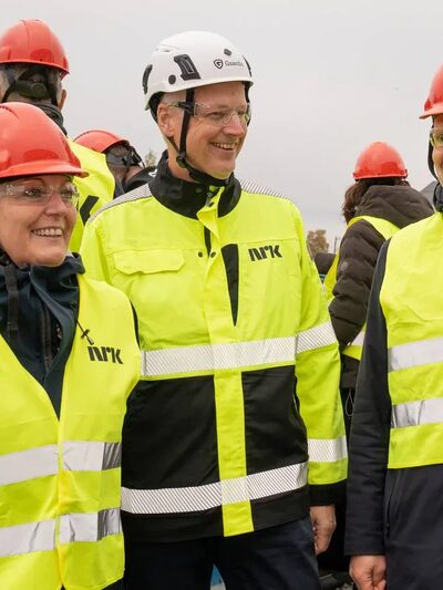 Personer i verneutstyr på byggeplass. Foto.