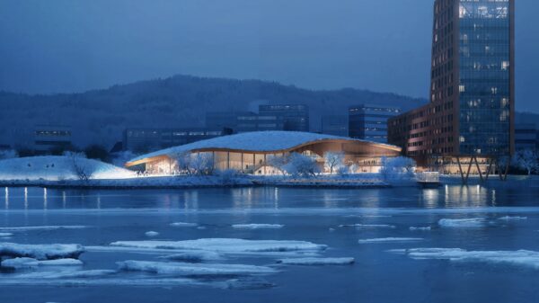 Bygg sett fra elv med isflak og med ås i bakgrunnen. Illustrasjon.