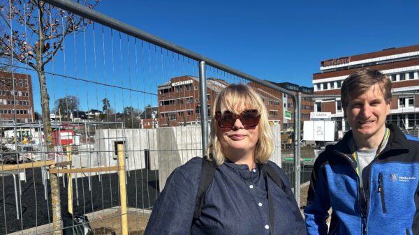 Kvinne og mann utenfor byggeplass. Foto.