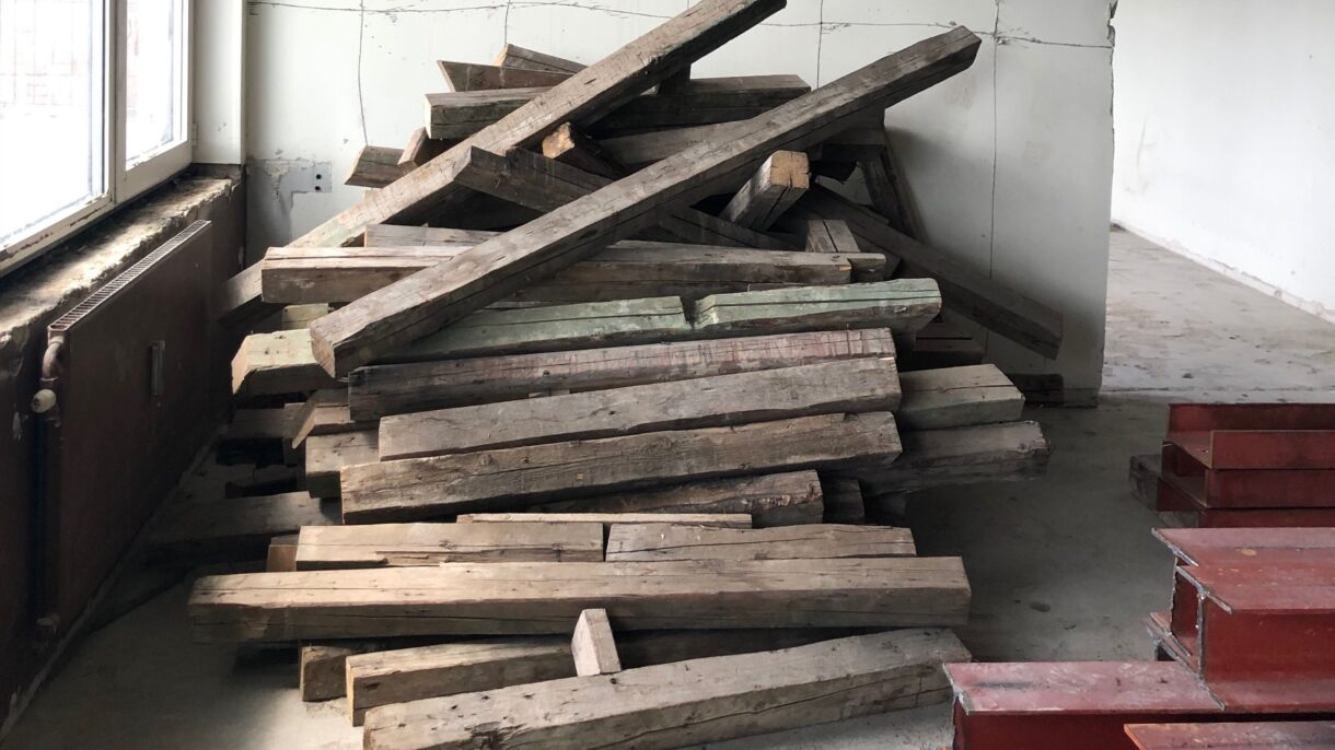 Disse gamle trestokkene fra bygget skal kappes, slipes og gjenbrukes som parkett på gulvet.