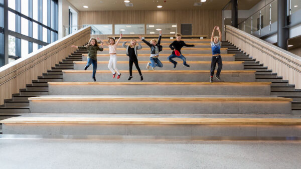 Sammen med småhus og boligblokker er skolebygg blant byggene som bruker minst energi. Bildet viser hoppende glade barn på Brynseng skole, som er en nær-nullenergiskole. Foto: Tove Lauluten