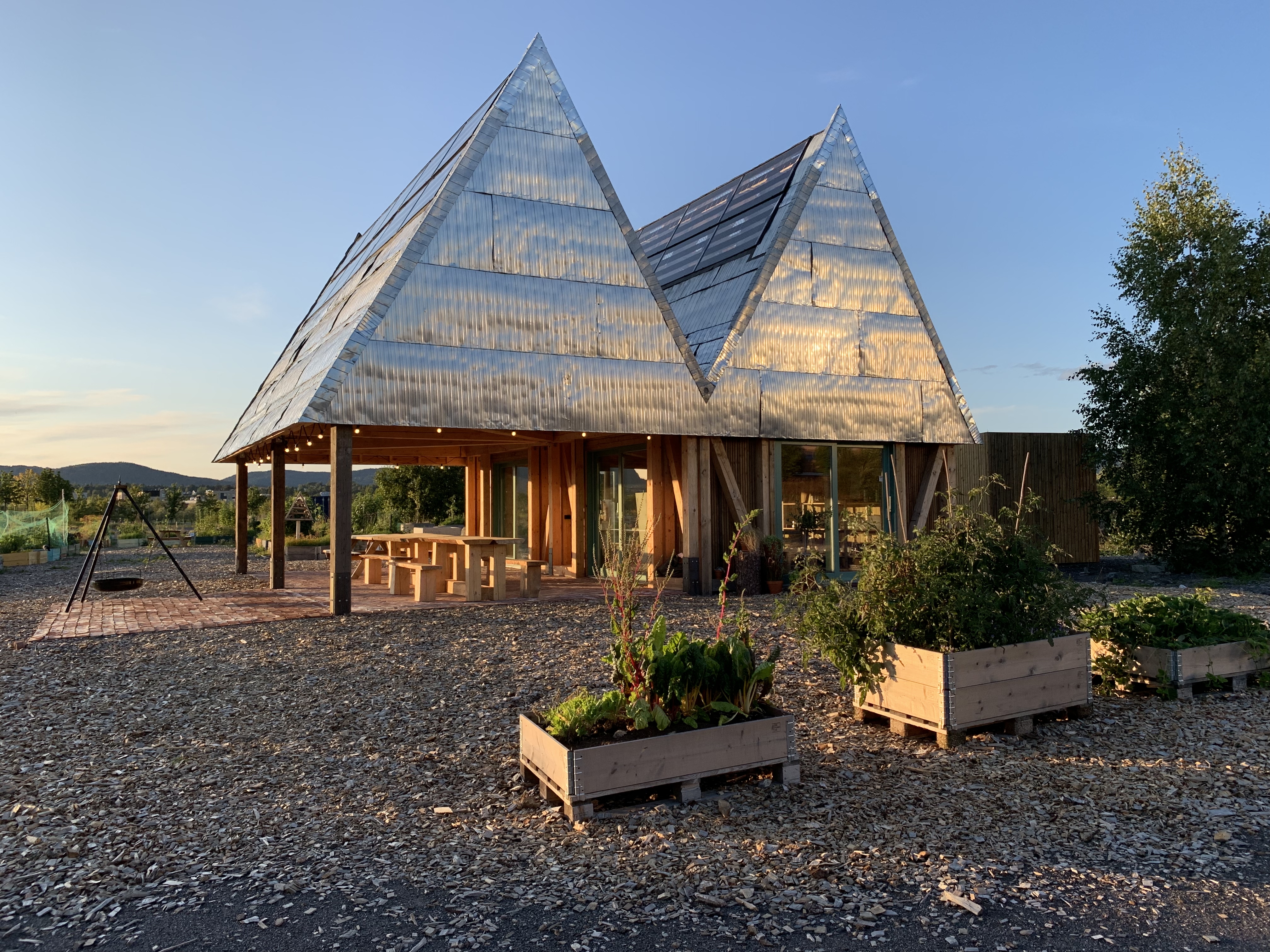 Midlertidig felleshus av gjenbruksmaterialer i dyrkningshage