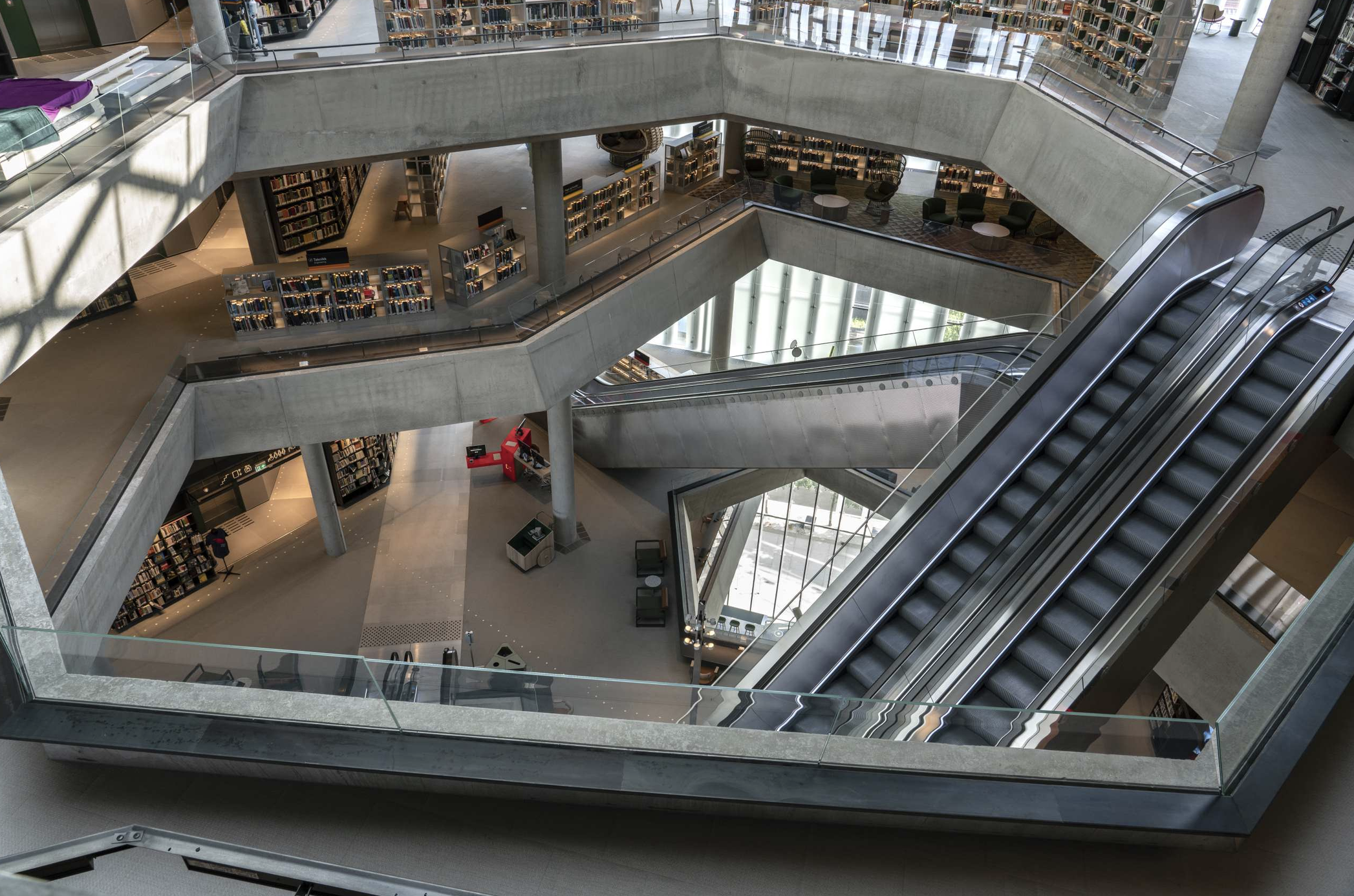 Et stort sammenhengende biblioteksrommet som strekker seg oppover i etasjene. Foto