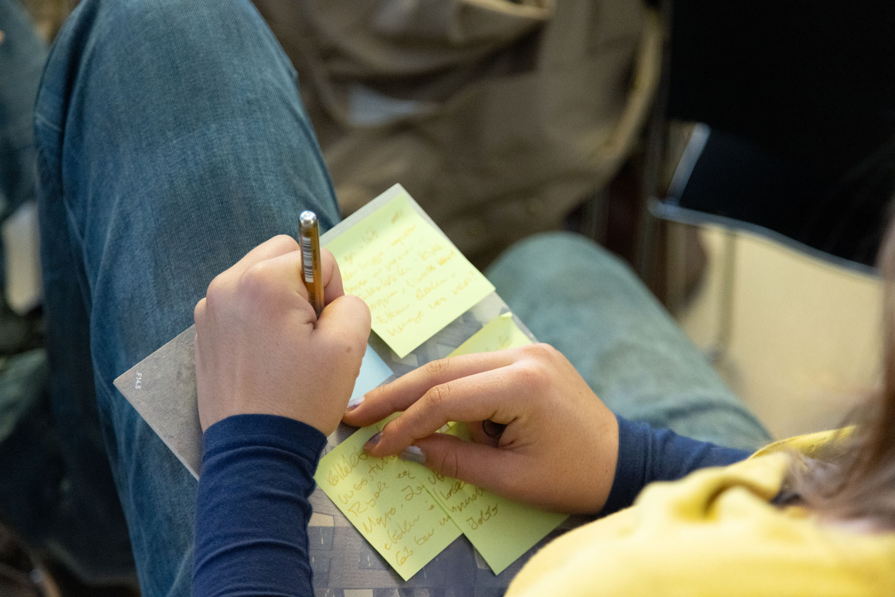 Person skriver på post it-lapp