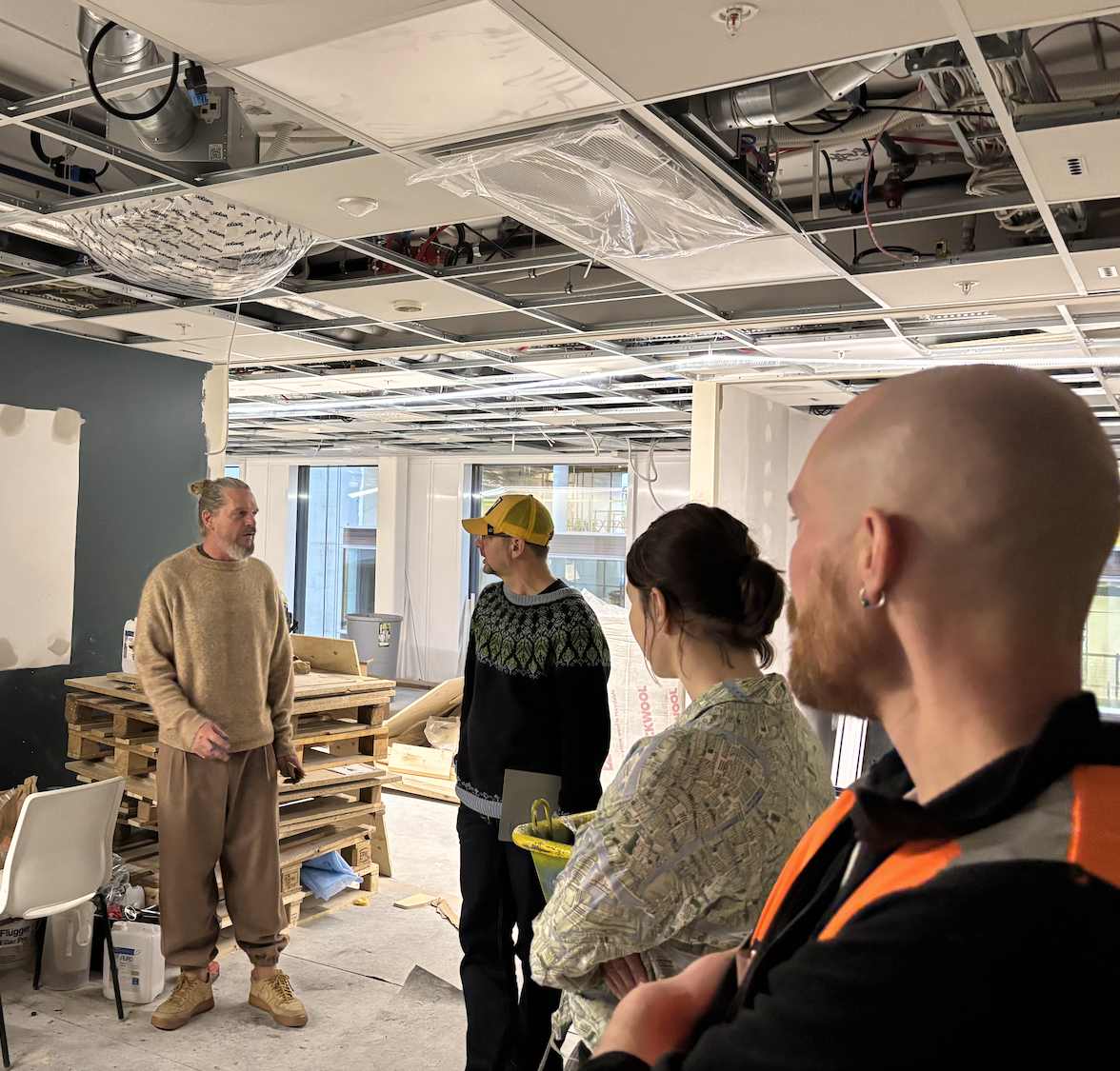 Patrick Gundersen fra leverandøren Grund viser en gruppe hvordan leirmaling er brukt i Sørkedalsveien 8.