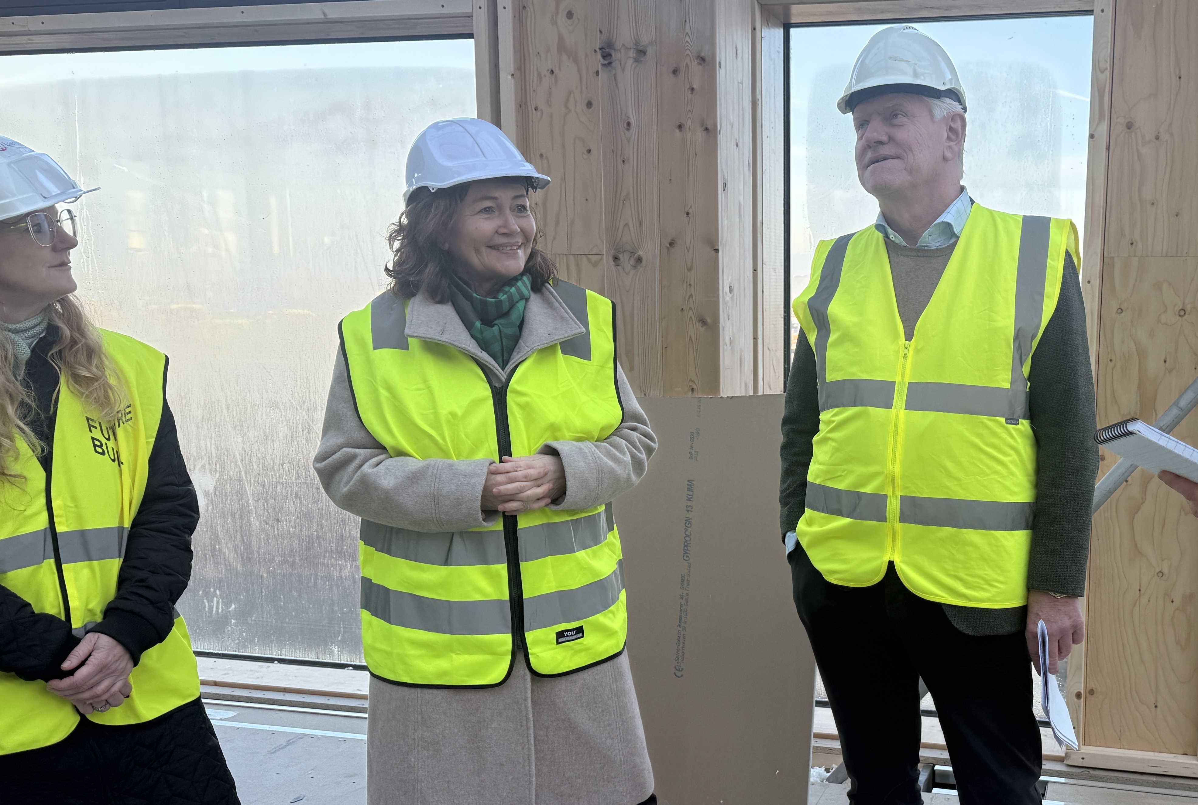 To kvinner og en mann med refleksvest og hjelm. Foto.