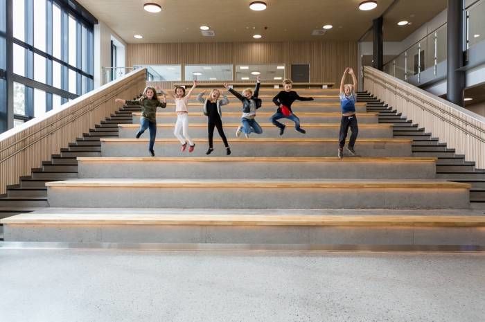 Sammen med småhus og boligblokker er skolebygg blant byggene som bruker minst energi. Bildet viser hoppende glade barn på Brynseng skole, som er en nær-nullenergiskole. Foto: Tove Lauluten